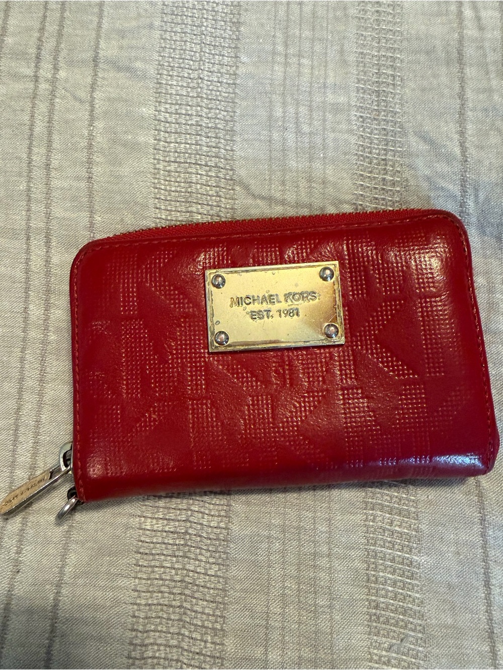 Michael Kors red monogram embossed zip-around wallet gold-toned logo plaque